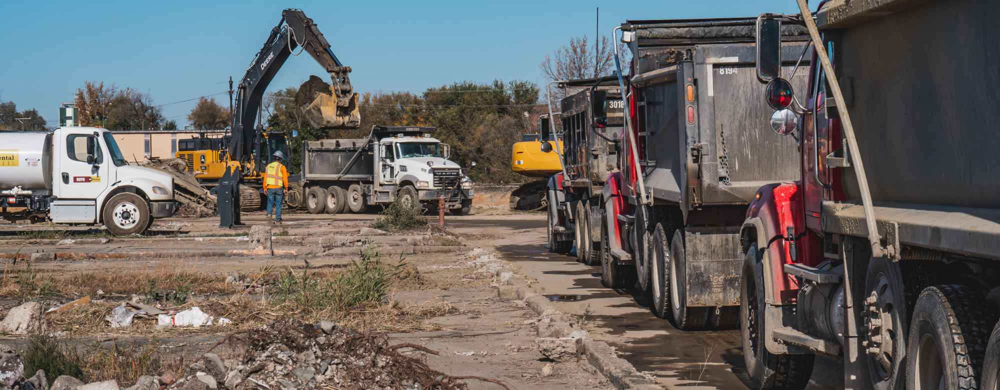 line of dump trucks waiting for excavator